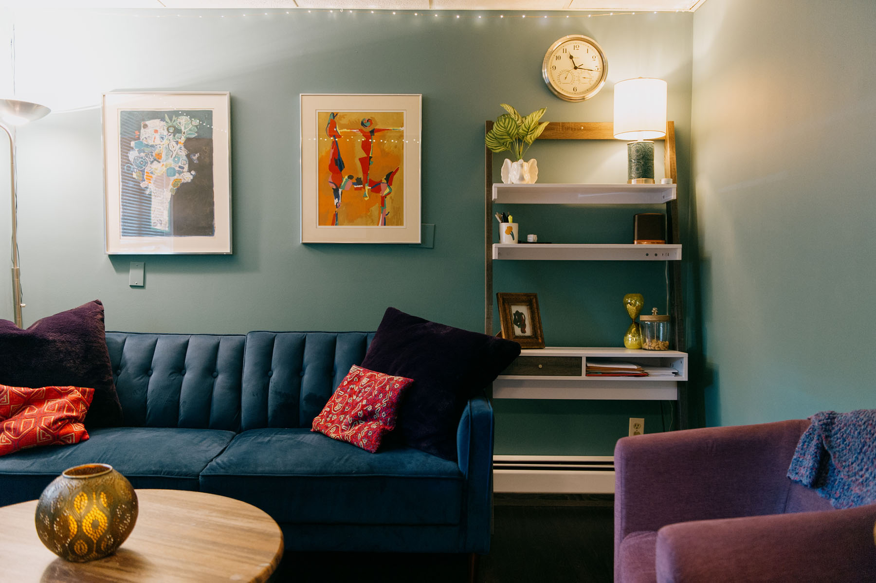 Therapy office at Blueprint Mental Health in NJ with a blue couch, teal wall, and paintings, providing mental health treatment NJ.