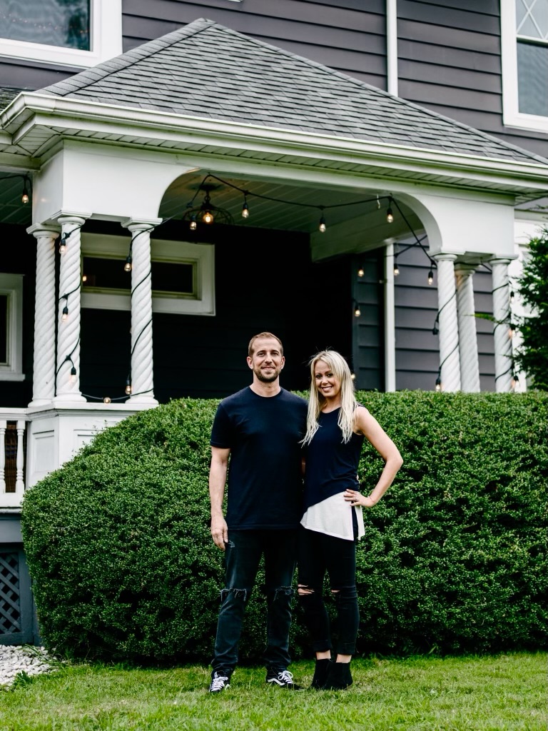John and Michele Mopper, the best therapists in NJ, standing in front of a dark grey Victorian home
