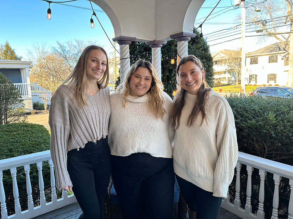 Sam, Nikki, and Deonna standing on the front porch of Blueprint Mental Health, smiling and ready to help you understand how to start therapy in Central New Jersey.